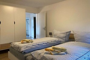 Ein Schlafzimmer mit einem Bett, einem Kleiderschrank und einer Tür zu einem anderen Raum.