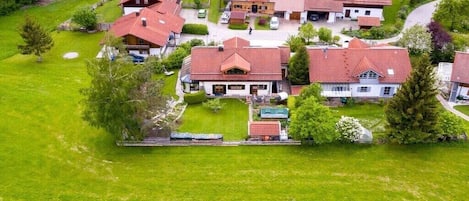 A residential area with multiple houses, a central building with a prominent entrance, and surrounding greenery.