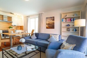 A modern living room with a sofa, a coffee table, and a bookshelf. - 3 (Beach Magic) in Villa Helene (Ostseebad Binz)