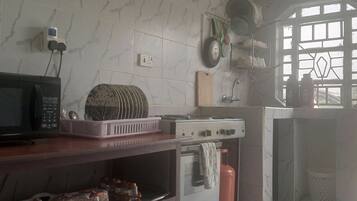 Una cocina equipada con microondas, estufa a gas y refrigerador.