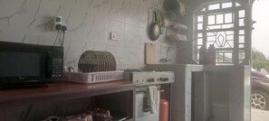 A kitchen with a microwave, a gas stove, and a refrigerator.