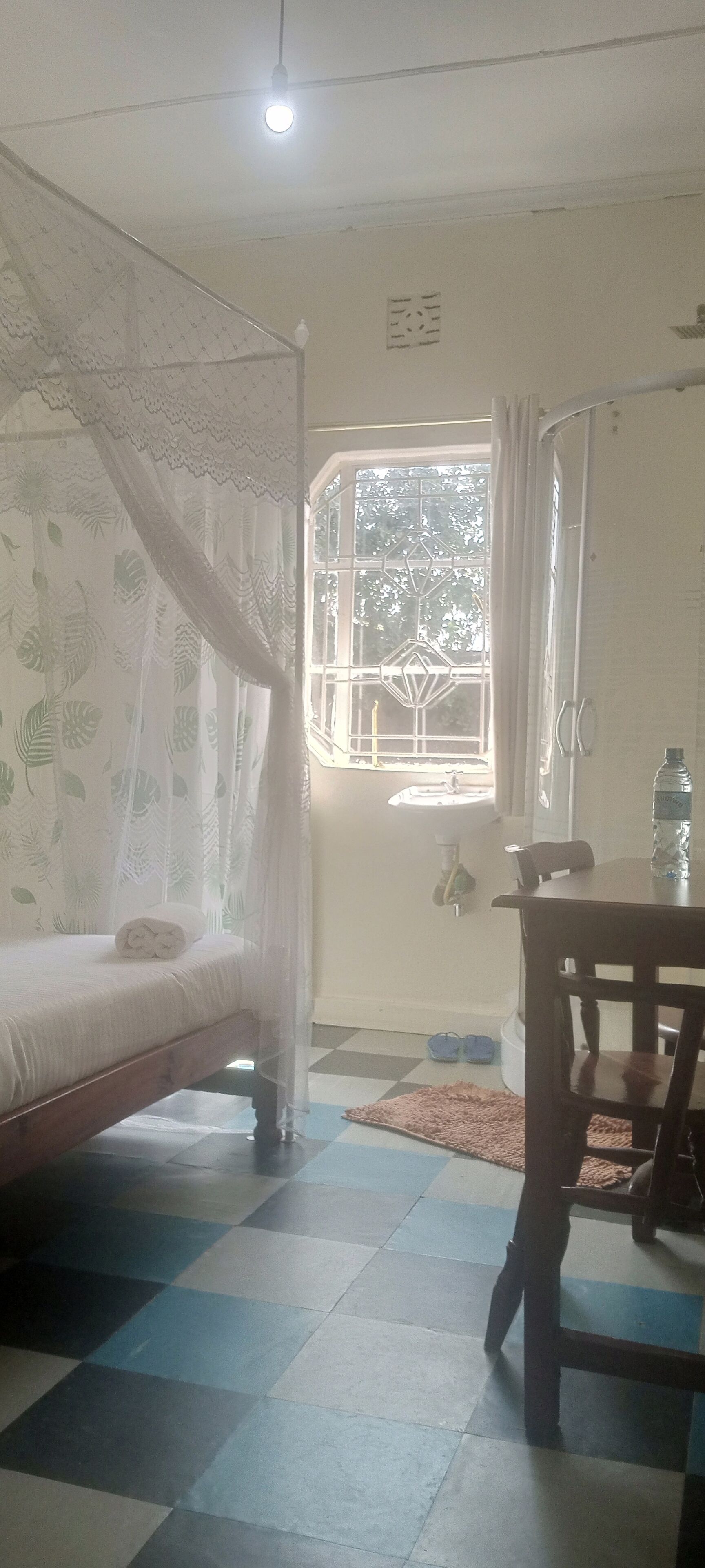 A room with a bed, a table, and a window.