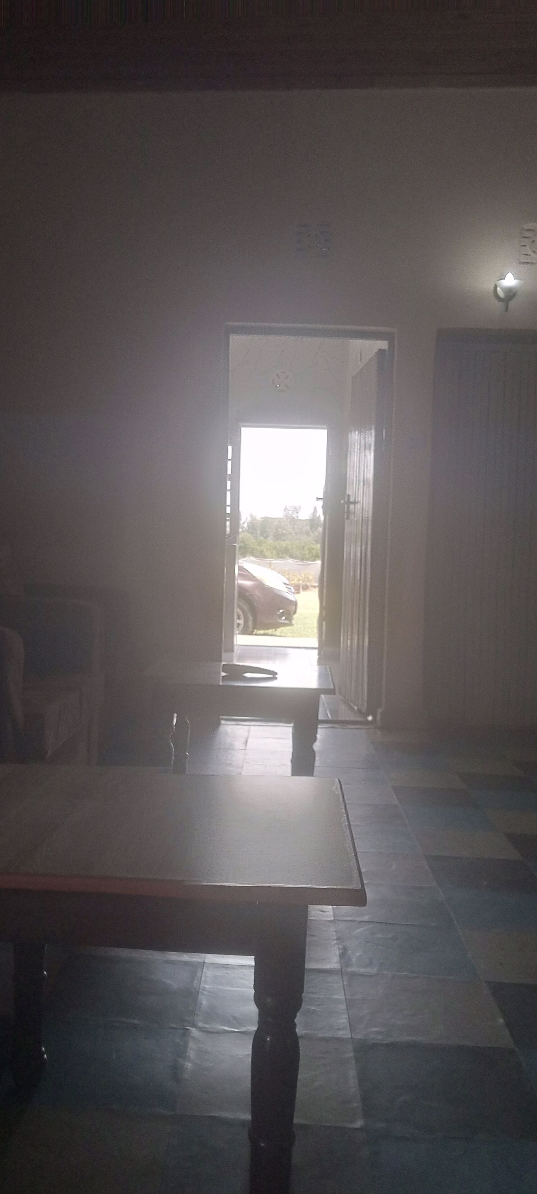 Una habitación con un gran escritorio y una puerta que da al exterior.