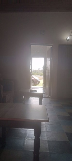 A room with a large table and a doorway leading outside.