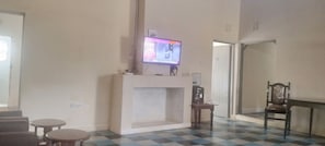 A living room with a fireplace, a television mounted above it, and a checkered floor.
