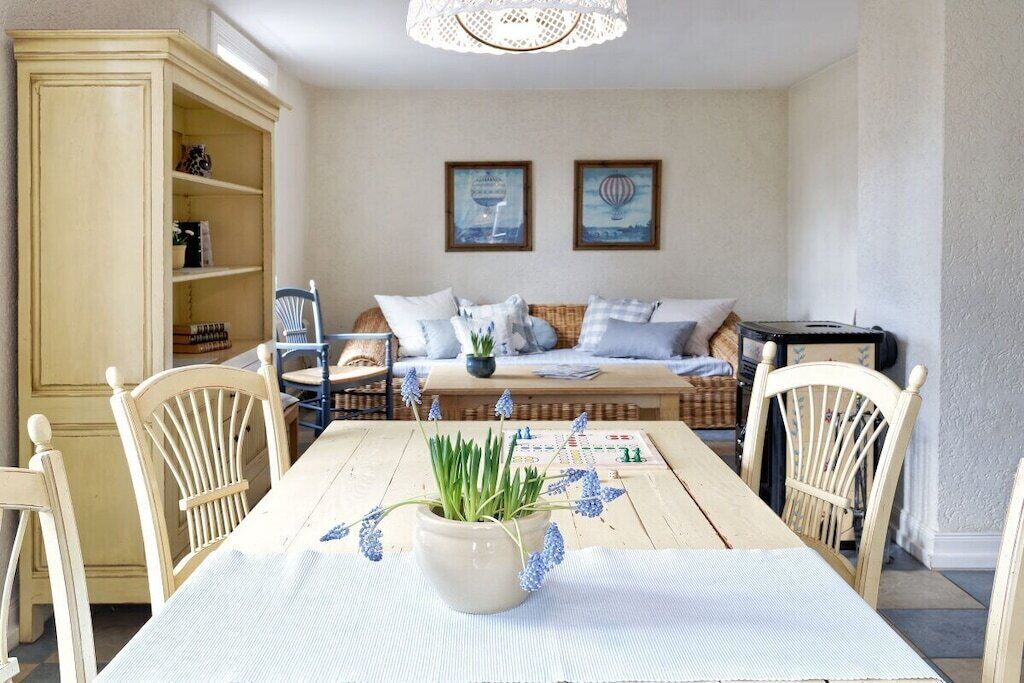 Ein Essbereich mit einem Tisch für vier Personen, einem Blumentopf und einem Bücherregal.