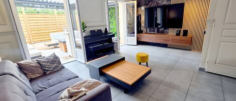 A modern living room with a sofa, coffee table, and a TV area with a wooden accent wall.