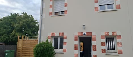 A two-story building with a flat facade, numbered 1510, featuring a small entrance with a door and windows with shutters.