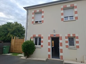 A two-story building with a flat facade, numbered 1510, featuring a small entrance with a door and windows with shutters. - Holiday Home “Chez Elie!” with Private Terrace, Garden, and Wi-Fi (Orléans)