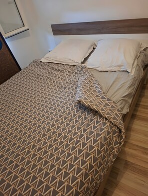 A bed with a geometric patterned bedspread and two pillows. - Holiday Home “Chez Elie!” with Private Terrace, Garden, and Wi-Fi (Orléans)
