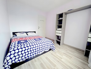 Un dormitorio con cama, armario y puerta.
