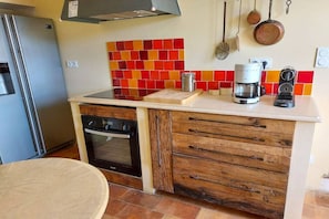 Eine kleine Küche mit integriertem Backofen, einer Kaffeemaschine und einem Toaster auf der Arbeitsplatte.