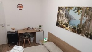 A bedroom with a bed, a desk, a chair, a small cabinet, and a wall-mounted clock. - Room Da Tea - Rooms with shared bathroom, mountain view, Wi-Fi, air conditioning (Olzai)