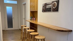 A hallway with wooden flooring, a bar area with stools, and a coffee-themed wall decoration. - Room Da Tea - Rooms with shared bathroom, mountain view, Wi-Fi, air conditioning (Olzai)