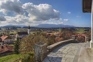 A town with a church, stone pathway, and a view of distant mountains. - Holiday apartment with 2 bedrooms (Bad Bayersoien)