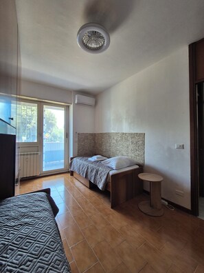 A bedroom with a bed, a small round table, and a window with a view. - Vrbo Property (Roma)