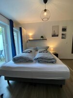 Ett sovrum med en säng, sänglampor och utsikt över omgivningen.