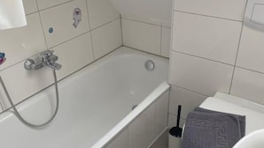 Um banheiro com banheira, pia e vaso sanitário.