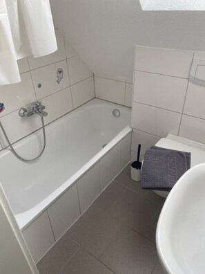 Ein Badezimmer mit einer Badewanne, einem Waschbecken und einer Toilette.