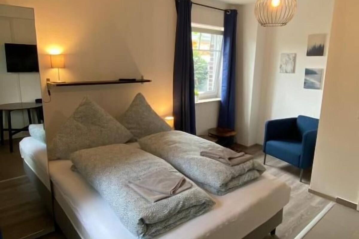 Ein modernes Schlafzimmer mit einem großen Bett, einem Schreibtisch und einem Stuhl.