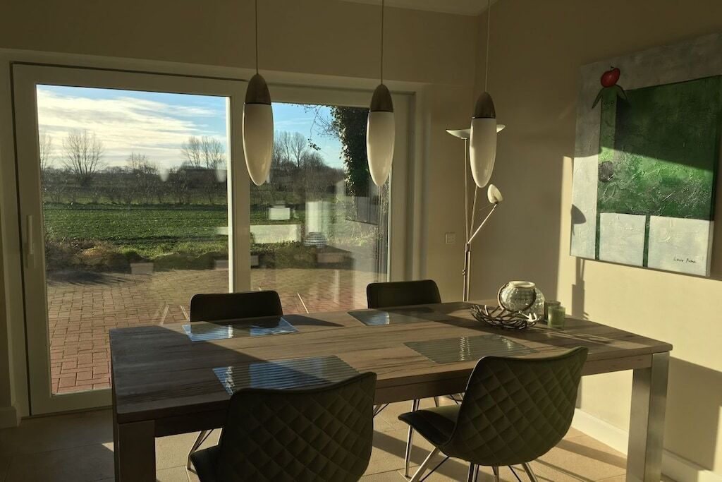 Un espace repas comprenant une table, des chaises et des luminaires suspendus.