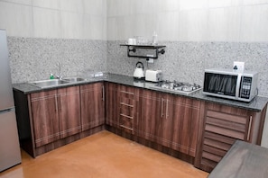 A kitchen with granite countertops, stainless steel appliances, and wooden cabinets. - Kruger Whispering Waters (Hazyview)