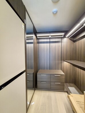 A modern closet with built-in lighting, wooden doors, and a mirror. - A brand-new, luxury high-end officetel in Seocho-dong (Seoul)