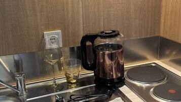 Una cocina moderna con una cafetera, una copa de vino y una toalla sobre la encimera.