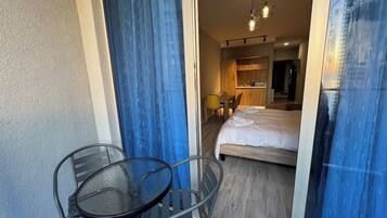 Habitación de hotel con cama, una mesa y sillas, y vistas al exterior.