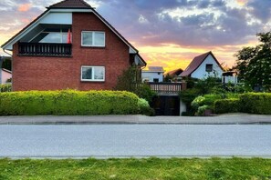 A residential house with a sloped roof, a visible balcony, and a gated entrance. - Holiday apartment with 1 bedroom (Ückeritz)