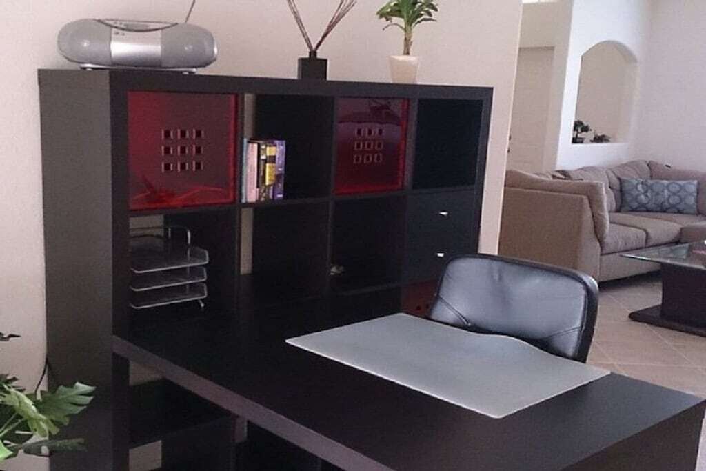 Un espace de bureau moderne comprenant un bureau, une chaise et un meuble avec plusieurs compartiments.