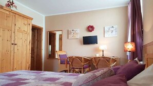 A hotel room with a bed, a desk with chairs, a television, and a mirror. - "BALTIC SAND" with balcony (Sassnitz)