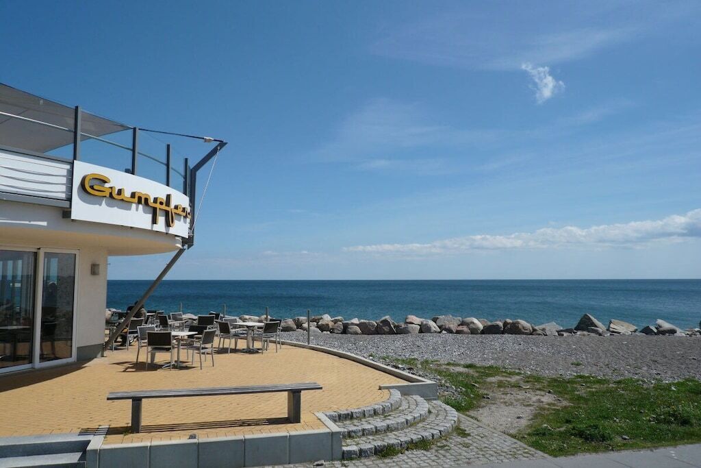A beachfront restaurant named 'Gumby' with outdoor seating and a view of the sea.