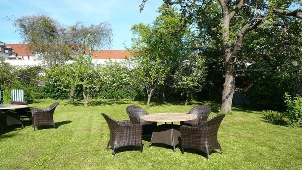 An outdoor dining area with wicker furniture and a round table. - "BALTIC SAND" with balcony (Sassnitz)