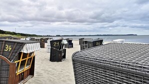 A beachside row of numbered beach huts with a view of the sea. - "BALTIC SAND" with balcony (Sassnitz)