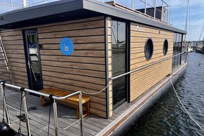 A wooden boat with a nameplate, a door, and a small seating area. - LaFe Flensburg Fjord (Egernsund)