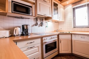 A kitchen with white cabinets, a microwave, a coffee maker, and a toaster. - Holiday home in the Harz Mountains with 2 bedrooms (Hasselfelde)