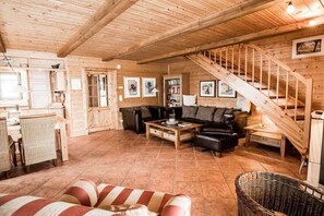 Ein Holzinnenraum mit Treppe, einer Couch, einem Couchtisch und einem Korbwannenkorb.