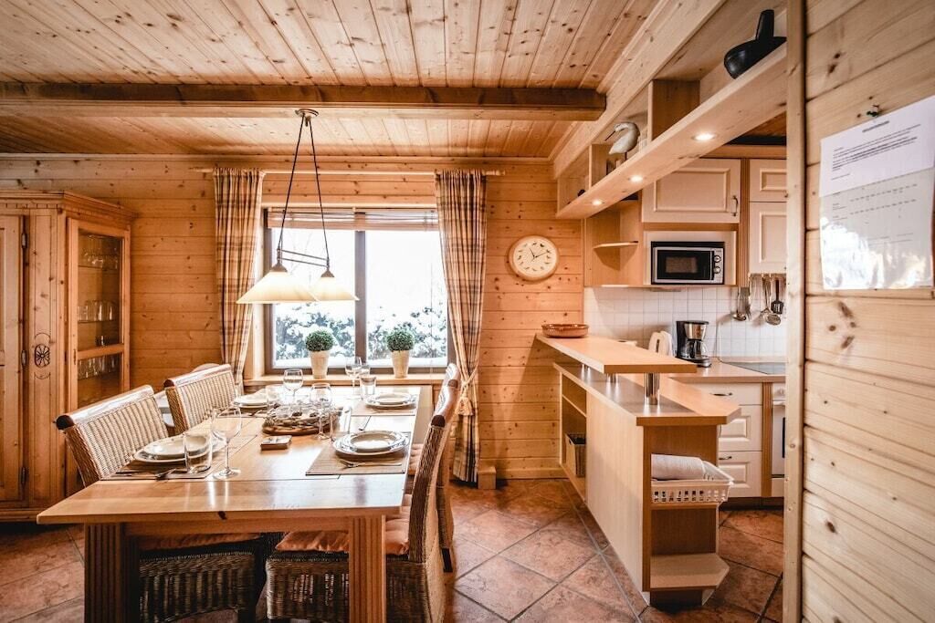 Un intérieur en bois comprenant un coin repas, une cuisine et une horloge au mur.
