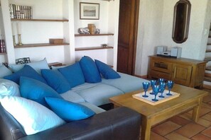 A living room with a sofa, coffee table, and shelves with books and decorative items. - Holiday home with 3 bedrooms (Esparron de Verdon)