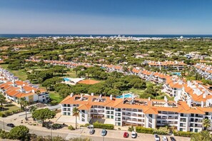 Zona residencial con edificios de apartamentos, espacios verdes y vista despejada al mar.
