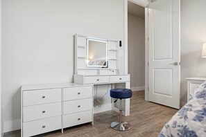 A white vanity with a mirror, drawers, and a stool. - Private Accommodation in Cape Coral—Waterfront with a Pool and a Stunning View (Cape Coral)