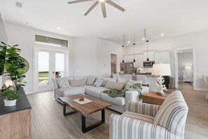 A spacious living area with a sectional sofa, a coffee table, and a striped armchair. - Private Accommodation in Cape Coral—Waterfront with a Pool and a Stunning View (Cape Coral)