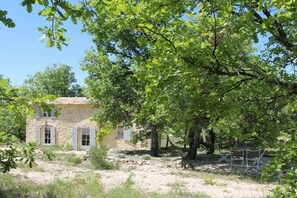 A stone building with a rustic appearance, surrounded by trees and a clear sky. - Holiday home with 2 bedrooms (Saint-Martin-de-Castillon)