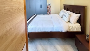 Ein Schlafzimmer mit einem Bett, einem Holzschrank und einem Nachttisch.