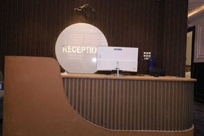 A reception desk with a sign that reads 'RECEPTION' and a computer monitor. - Aachman Hotal Restaurant (Bulandshahr)