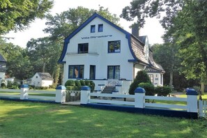 A two-story Villa Miramare with a white facade and blue trim, a white picket fence, and a number 48 sign. - Beach Villa Miramare / Apt. Sea Urchin (Klütz)