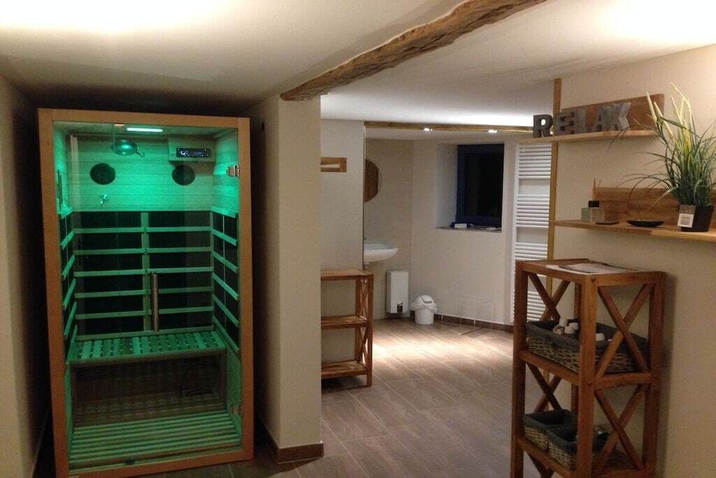 Een kamer met een sauna, houten planken en een raam.