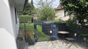 A patio with a table and chairs, a small garden, and a metal fence. - Holiday home in Cuxhaven with swimming pool (Cuxhaven)