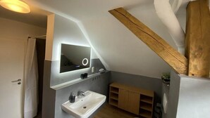 A modern bathroom with a built-in sink, a mirror, and wooden beams. - Holiday home "On the cliffs" Apt. 3 (Boltenhagen Redewisch)